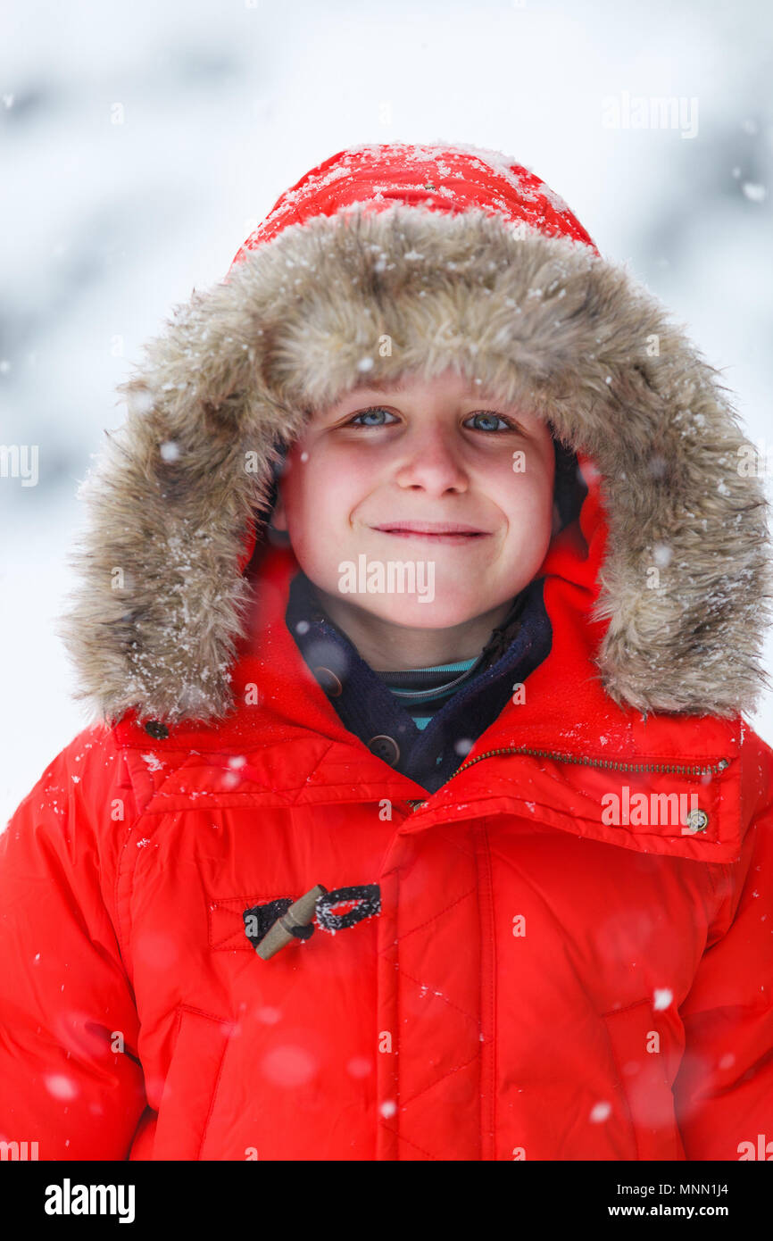 Süße Junge in einer roten parka Daunenjacke im Freien auf der schönen  winter schnee Tag Stockfotografie - Alamy