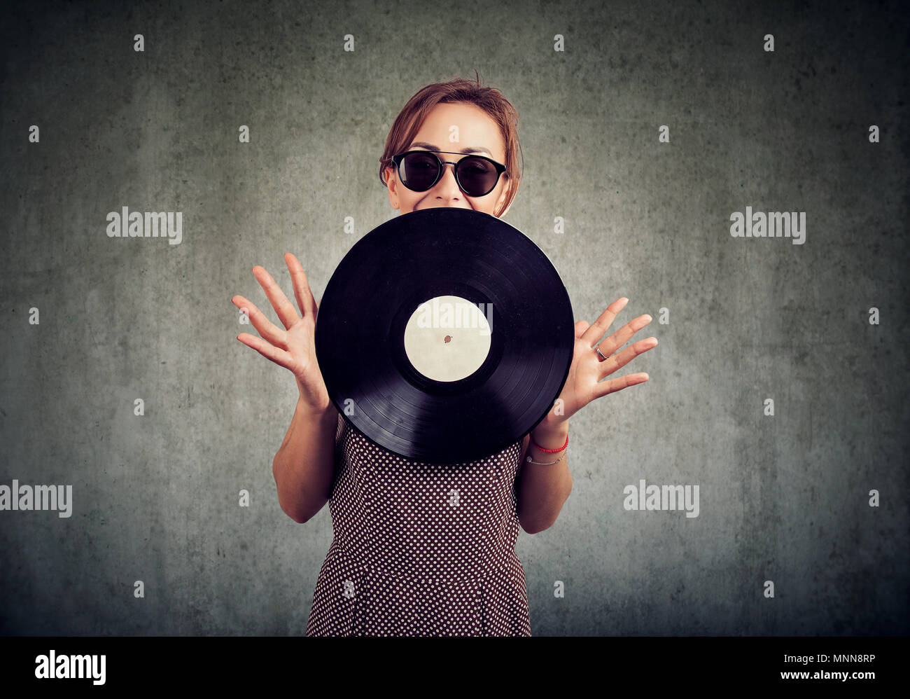 Freudige schöne junge Frau in Sonnenbrille mit einem Vintage vinyl Stockfoto