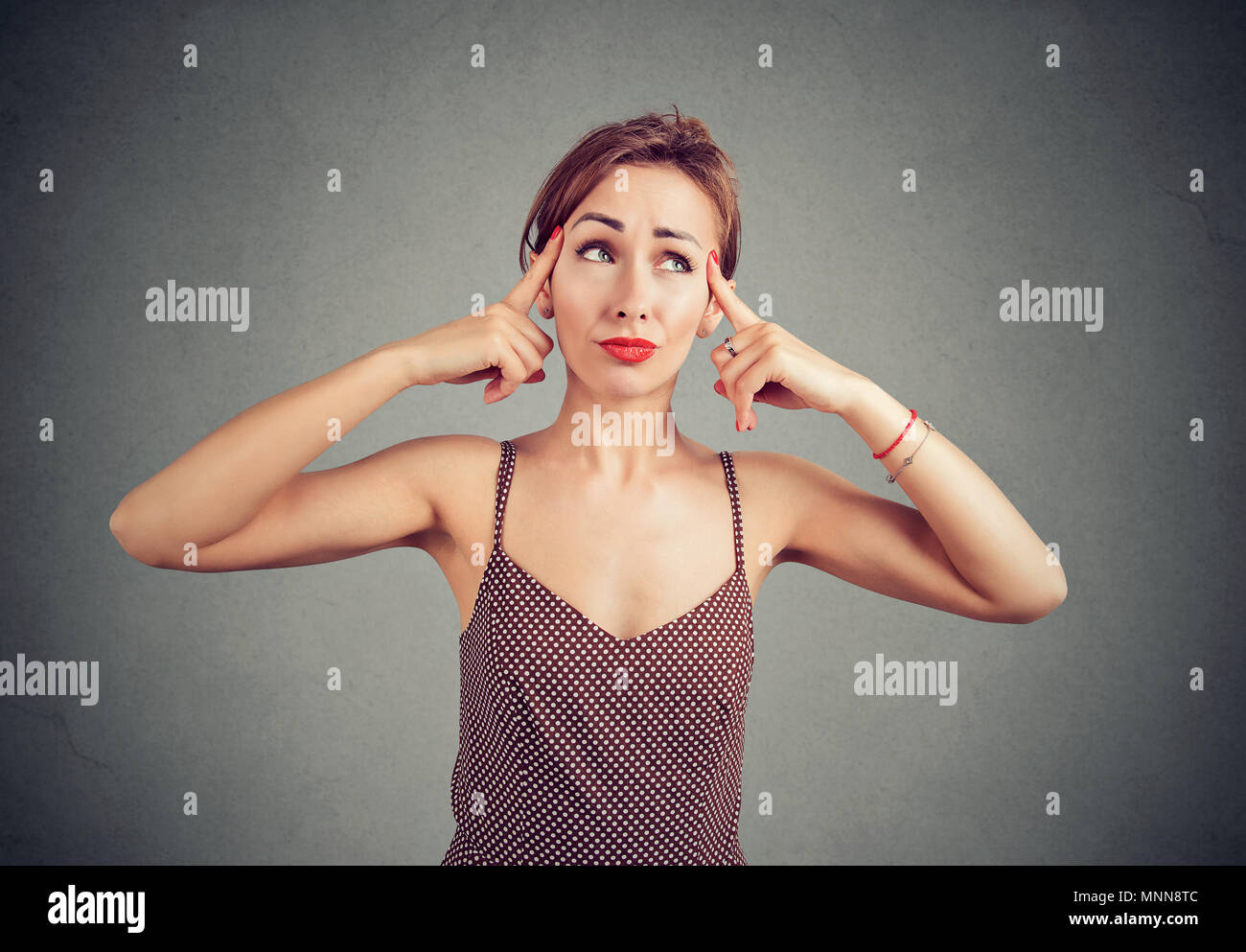 Peprlexed Frau versucht, mit Gedanken zu sammeln, Gedanken über etwas, mit Zweifel nach oben. Stockfoto