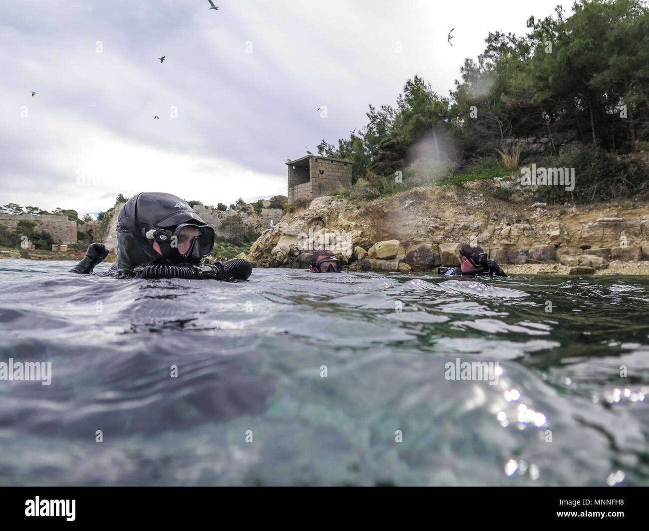 Die SOUDA BUCHT, Griechenland (9. März 2018) Marines mit maritimen Raid-Kraft (MRF), 26 Marine Expeditionary Unit (MEU), Oberfläche aus dem Wasser nach Erreichen einer simulierten Ziel während der Tauchausbildung in der Marinebasis Souda Bay, Griechenland, 9. März 2018. Die MRF durchgeführt, um die Ausbildung an der NATO Maritime Verbot Operations Training Center (NMIOTC) tauchen Kenntnisse zu erhalten. Stockfoto