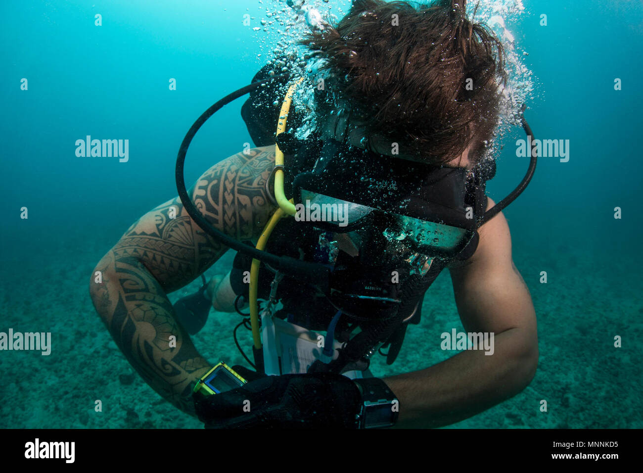 Marine Diver 1. Klasse Jesse Stigibauer, den Marinestützpunkt Guam Dive Locker zugeordnet, überprüft seinen Tauchcomputer während des Tauchgangs in Apra Harbor in der Nähe von Naval Base Guam, 16. März 2018. Der Tauchgang wurde zur Unterstützung der Bemühungen, die von der Marine positives Engagement für die Umwelt im gesamten Gemeinsamen Region Marianen zu fördern. Stockfoto