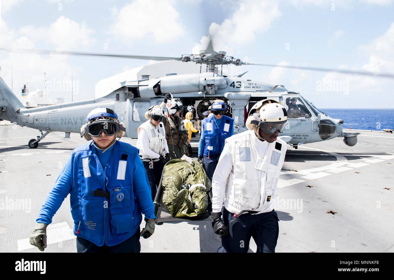 Ozean (16. März 2018) Segler Transport ein mock Patienten von einem MH-60S Sea Hawk Hubschrauber, angeschlossen an die "Wildcards" der Hubschrauber Meer Combat Squadron (HSC) 23 die Triage Zentrum während einer Messe Unfallversicherung Feld integrierte Übung an Bord Military Sealift Command Hospital Ship USNS Mercy (T-AH 19) in Vorbereitung auf die Pazifische Partnerschaft 2018 (PP18). PP18's Mission ist es, gemeinsam mit Gastgeber und Partner Nationen zu arbeiten regionaler Interoperabilität und Disaster Response Funktionen, erhöhen die Stabilität und Sicherheit in der Region zu stärken, und neue und dauerhafte Freundschaften über die Indo-Pa fördern Stockfoto