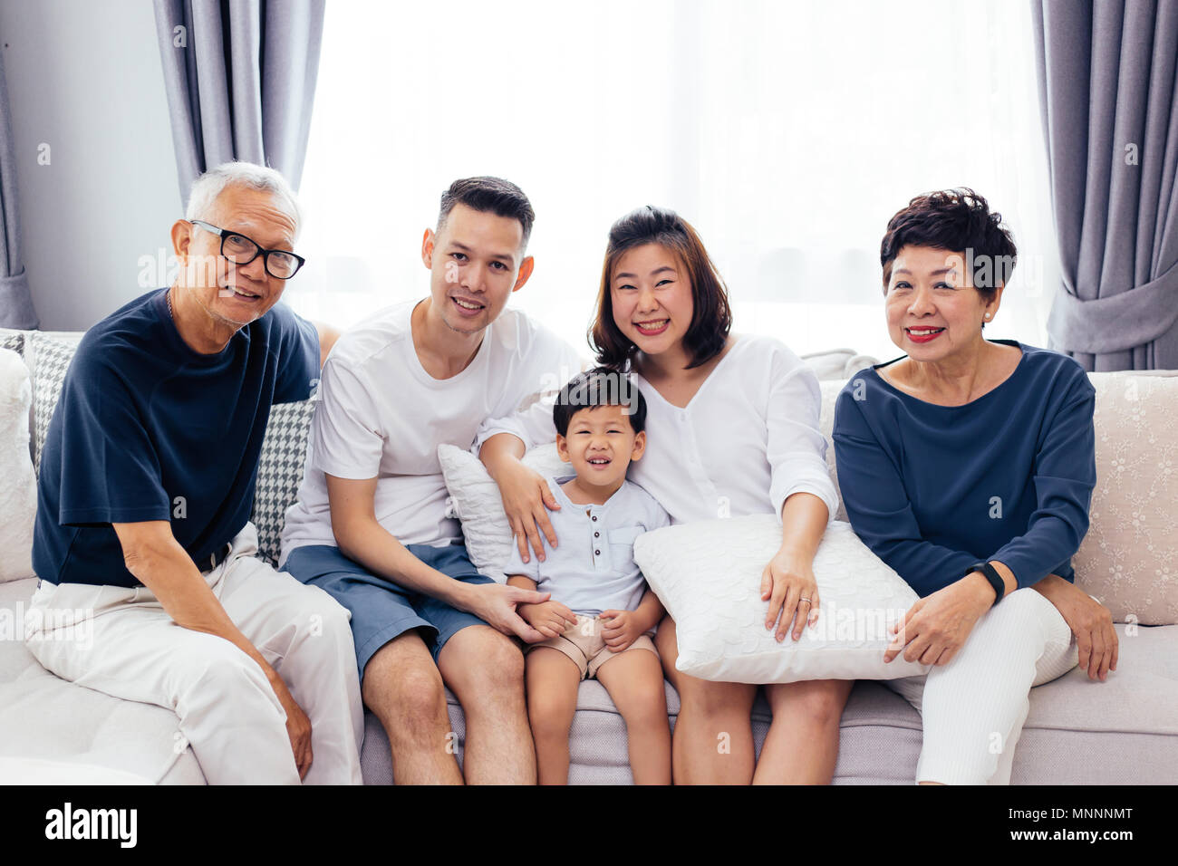 Gerne Asiatische erweiterte Familie auf dem Sofa sitzen zusammen, für die Gruppe Fotos posiert Stockfoto