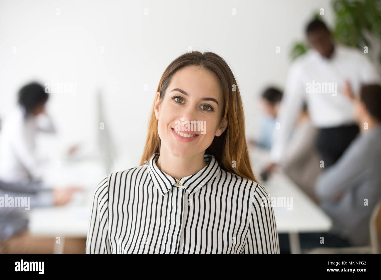 Attraktive Frau Business Leader lächelnd auf Kameraköpfe Stockfoto