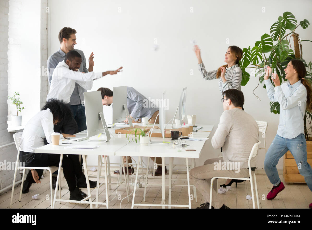 Happy gemischtrassiges Team werfen zerknittertes Papier Bälle Spaß Stockfoto