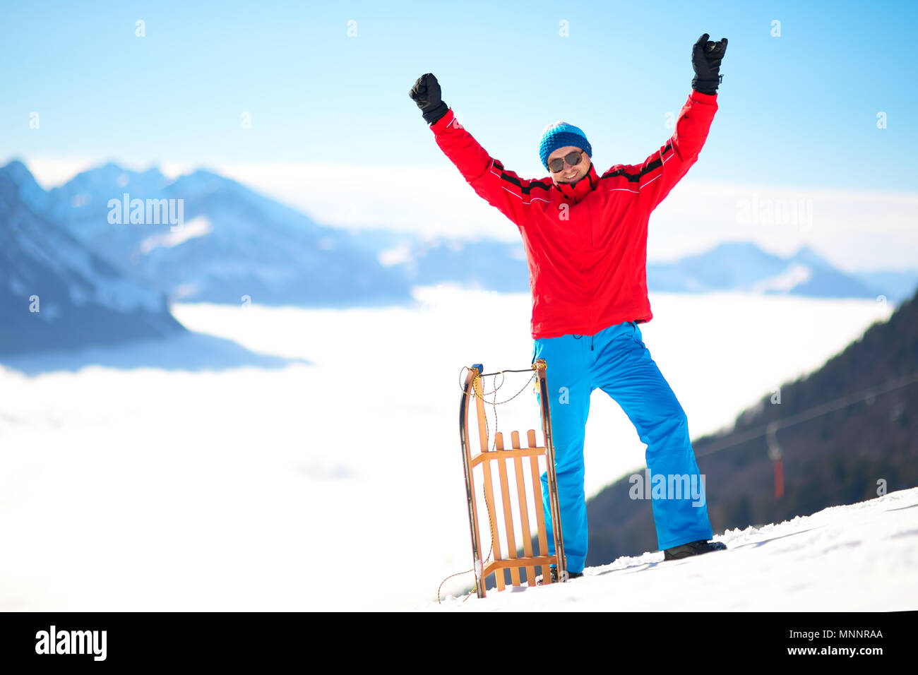 Jungen attraktiven Mann bereit, Rodeln in den Schweizer Alpen im Winter Ferien zu gehen. Stockfoto