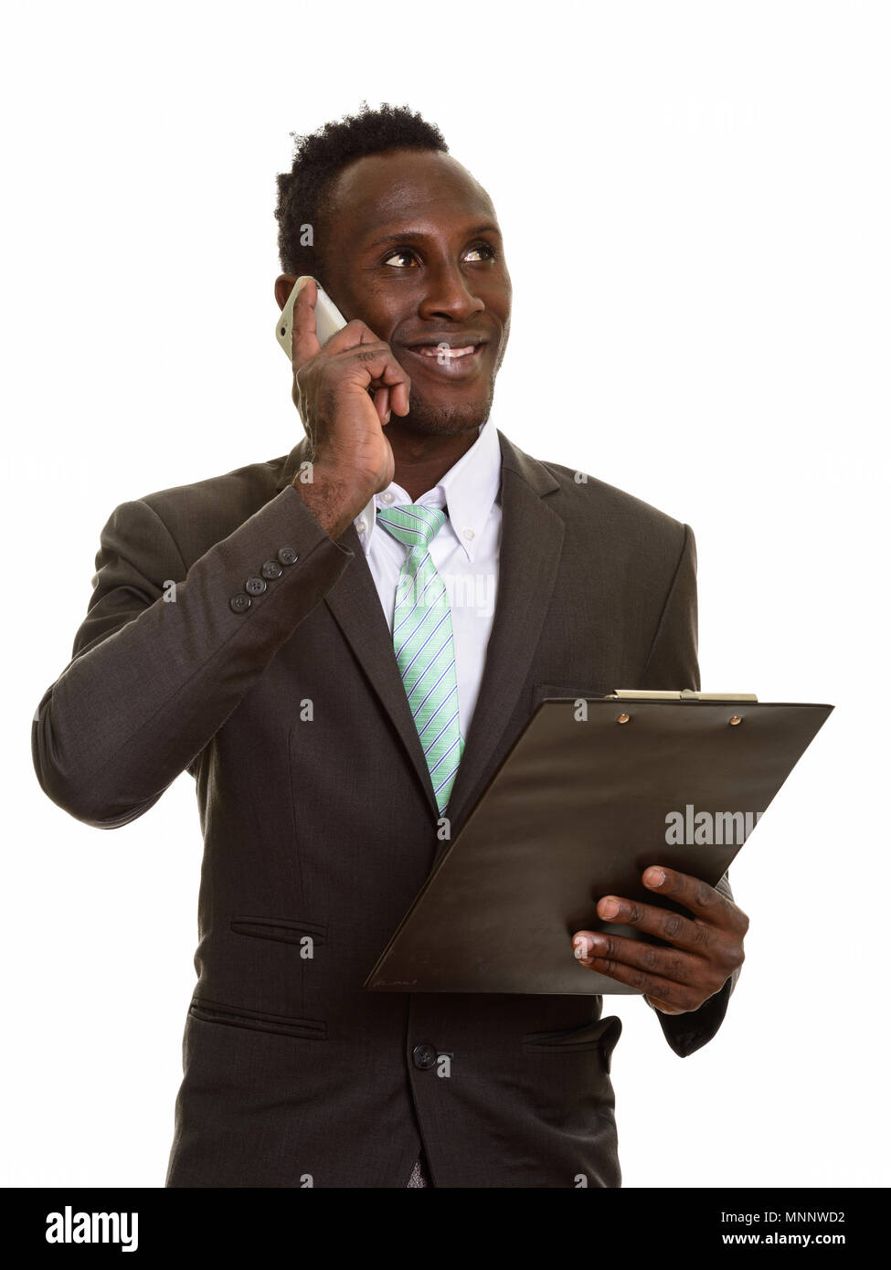 Nachdenkliche junge glücklich Afrikanischen Geschäftsmann lächelnd und Reden o Stockfoto