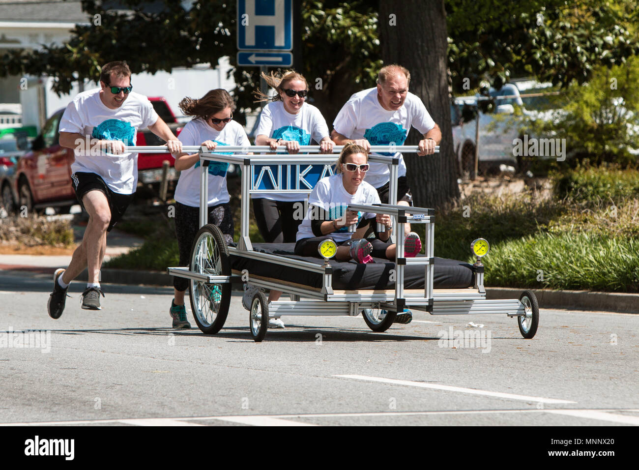 Ein Team drückt ein speziell gestaltetes Bett in einem nächstenliebegeldbeschaffers Bett Rennen am 21. April 2018 in Lawrenceville, GA. Stockfoto