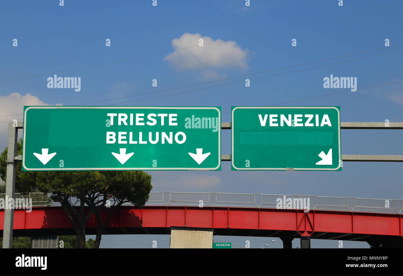 Grüne Hinweisschild in Italien, dass die Straße nach Venedig Belluno und Triest Stockfoto