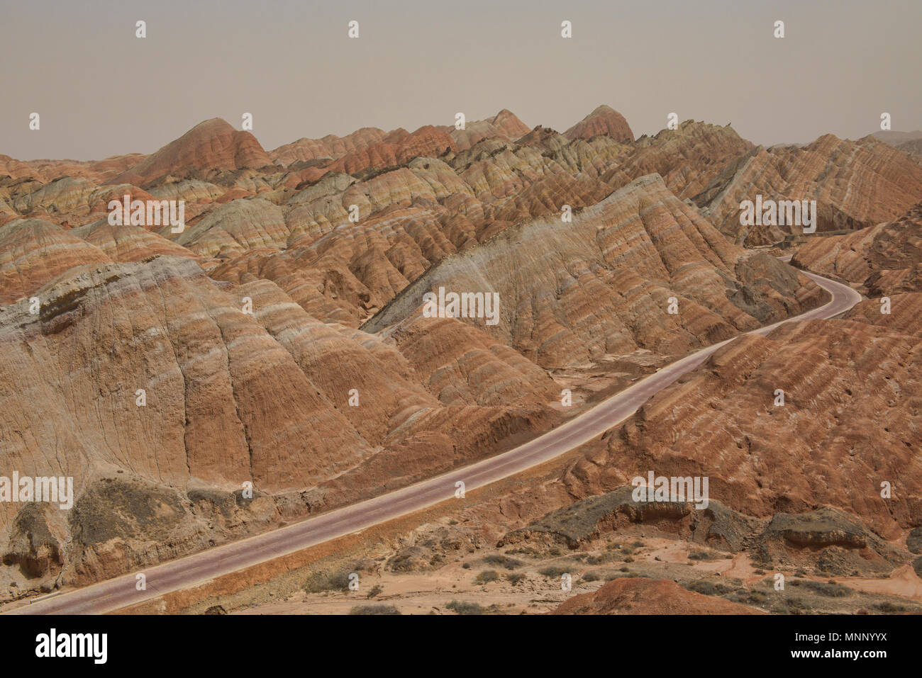 Kurvenreiche Straße durch die malerische Zhangye Danxia Relief geologischen Park, Gansu, China Stockfoto