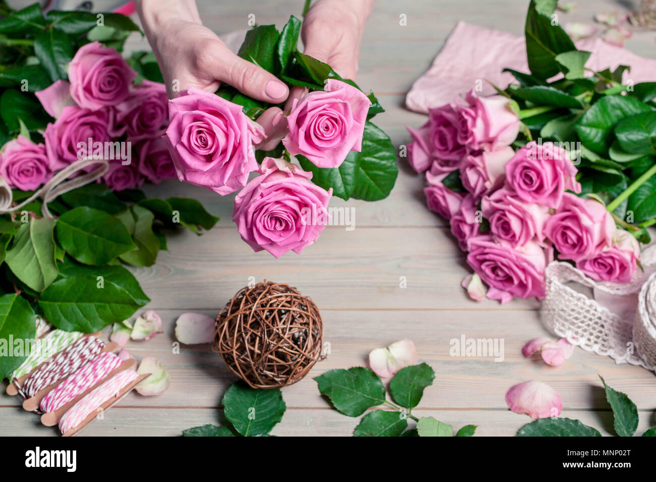 Florist bei der Arbeit. Elegante weibliche Hände sammeln eine Hochzeit Blumenstrauß aus Rosen. Die Menschen in den Prozess der Arbeit Stockfoto