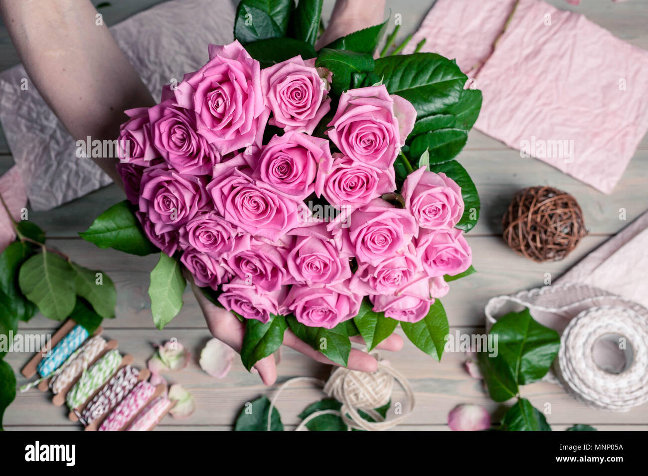 Anmutige weibliche Hände sammeln ein Blumenstrauß aus Rosen. Florist bei der Arbeit Stockfoto