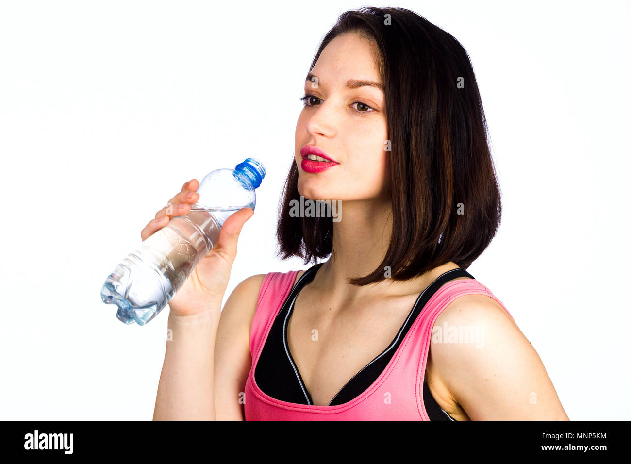 Junge Mädchen mit einer Flasche Trinkwasser auf einem weißen Hintergrund, Studio, Beleuchtung Stockfoto