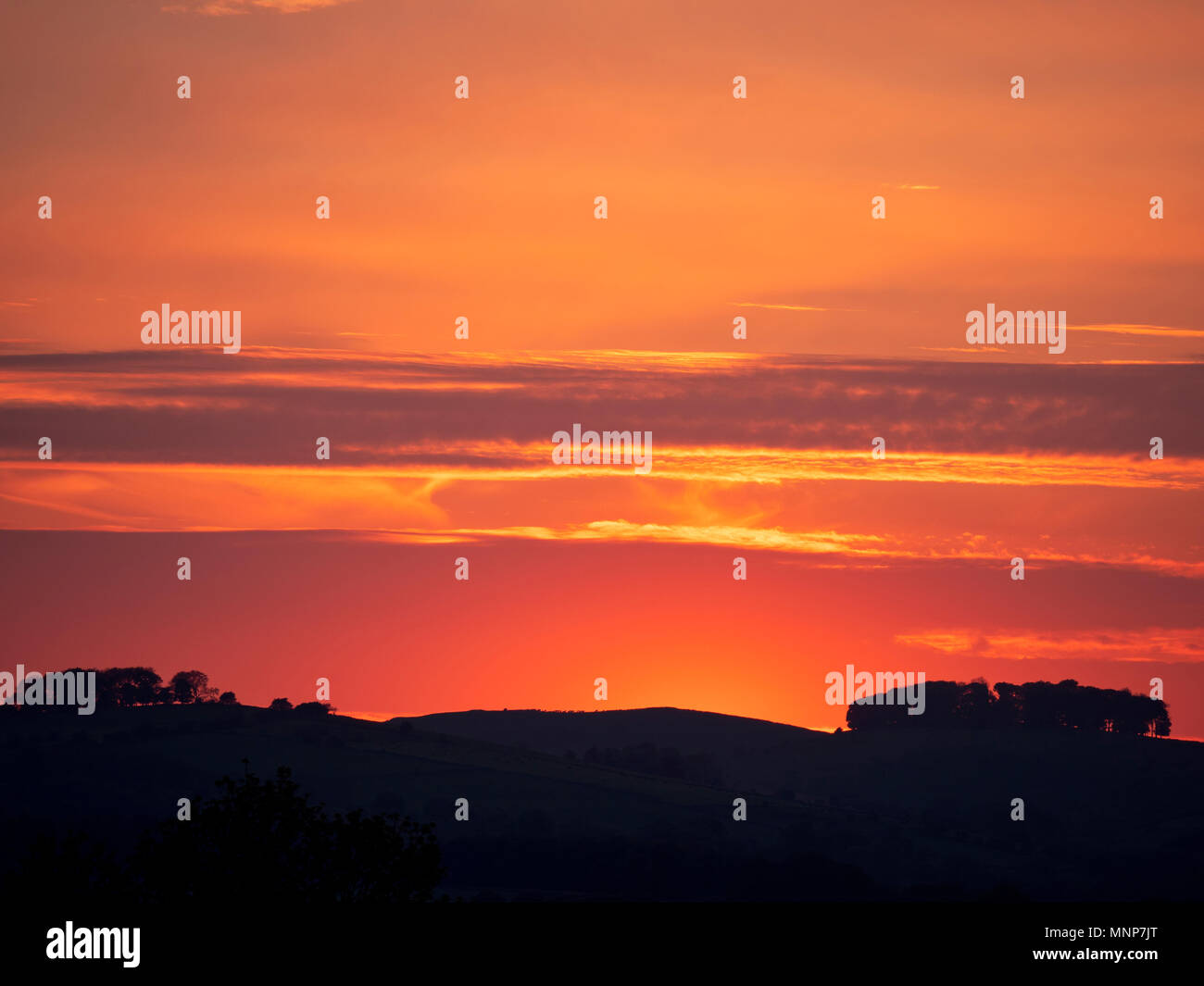 Peak District, Derbyshire, UK. 18 Mai, 2018. UK Wetter: spektakulären Sonnenuntergang über der alten Wälder Hazleton Büschel Cairn in der Nähe von Thorpe aus Ashbourne, Derbyshire Peak District National Park Credit: Doug Blane/Alamy Leben Nachrichten genommen Stockfoto