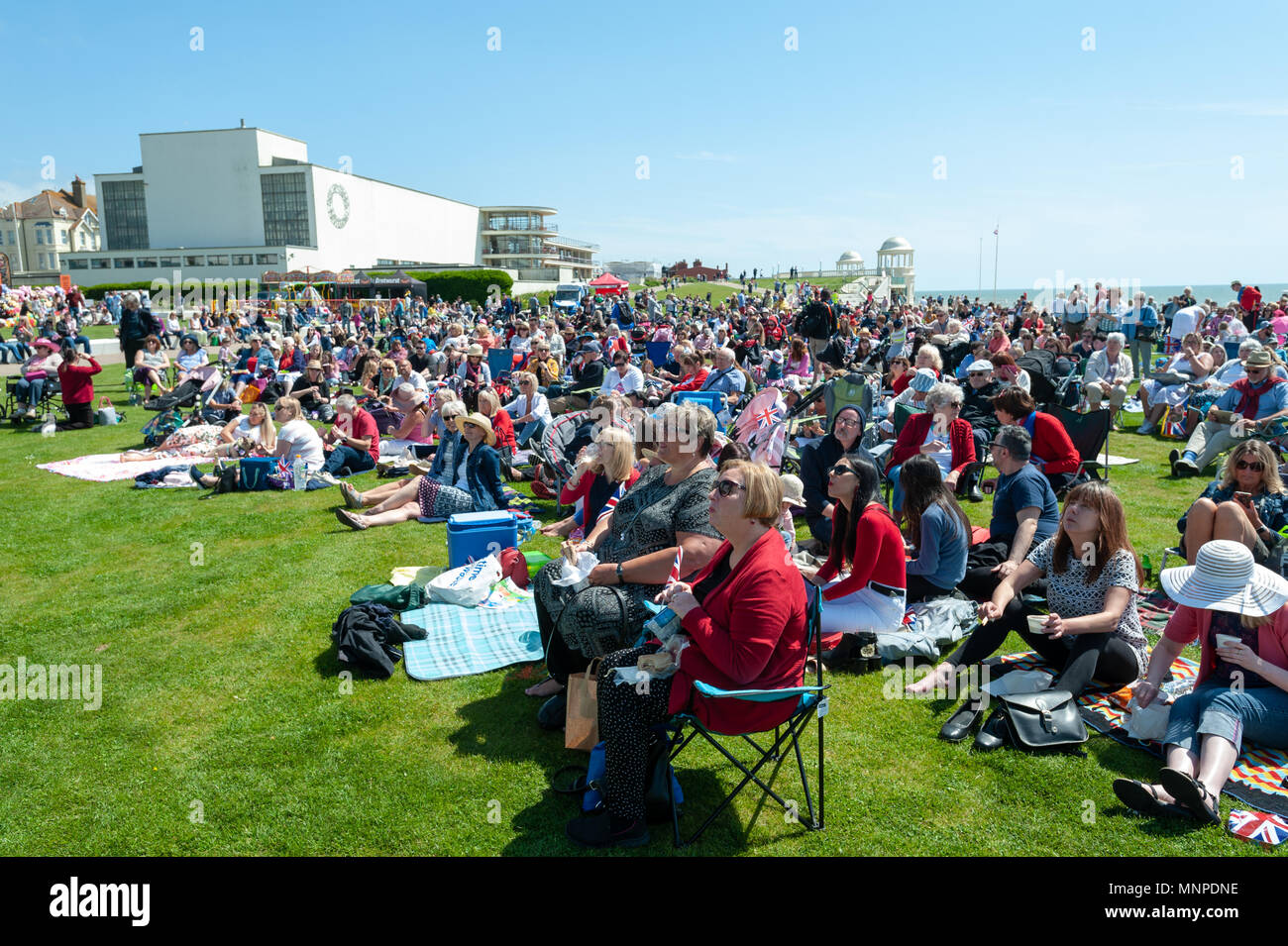 Die Menschen sehen Prinz Harry und Meghan Markle Hochzeit auf einem großen Bildschirm an eine königliche Hochzeit Event an der Küste von Bexhill-on-Sea, East Sussex, UK. Stockfoto