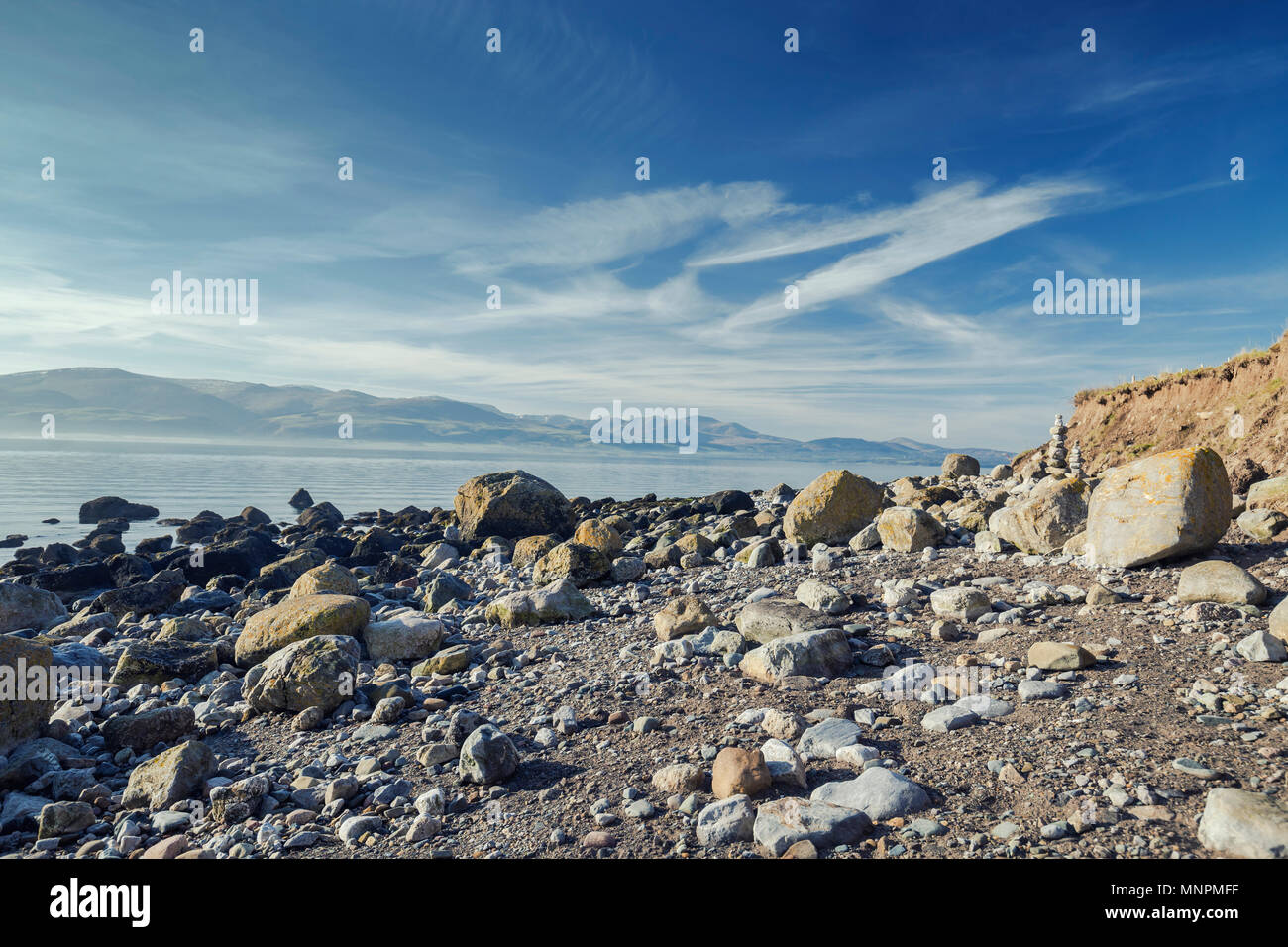 Felsigen Ufer Menai Strait mit spektakulärem Blick auf die Berge von Snowdonia. Insel Anglesey im Norden von Wales. Großbritannien Stockfoto