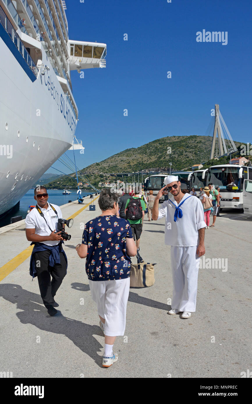 Zurück Blick auf Frau Passagier verlassen Kreuzfahrtschiff für Dubrovnik Fotograf Mann & Crew Helfer wollen für Fotos neben Liner auf Port Jetty darstellen Stockfoto