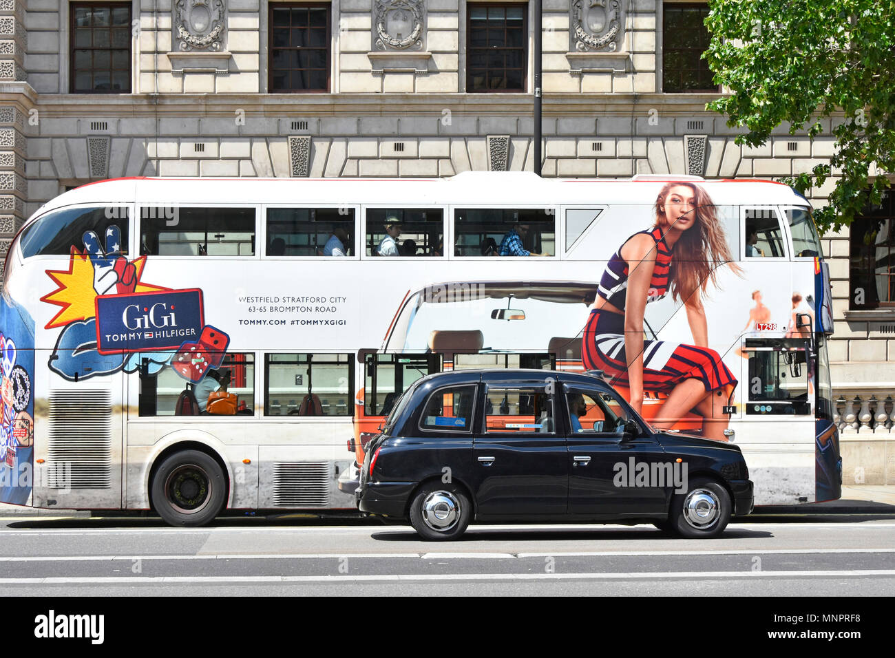Whitehall London Street Scene black cab vorbei Anzeige Seite Blick auf die London öffentliche Verkehrsmittel Bus mit fashion model sitzen auf der Vorderseite des Taxi UK Stockfoto