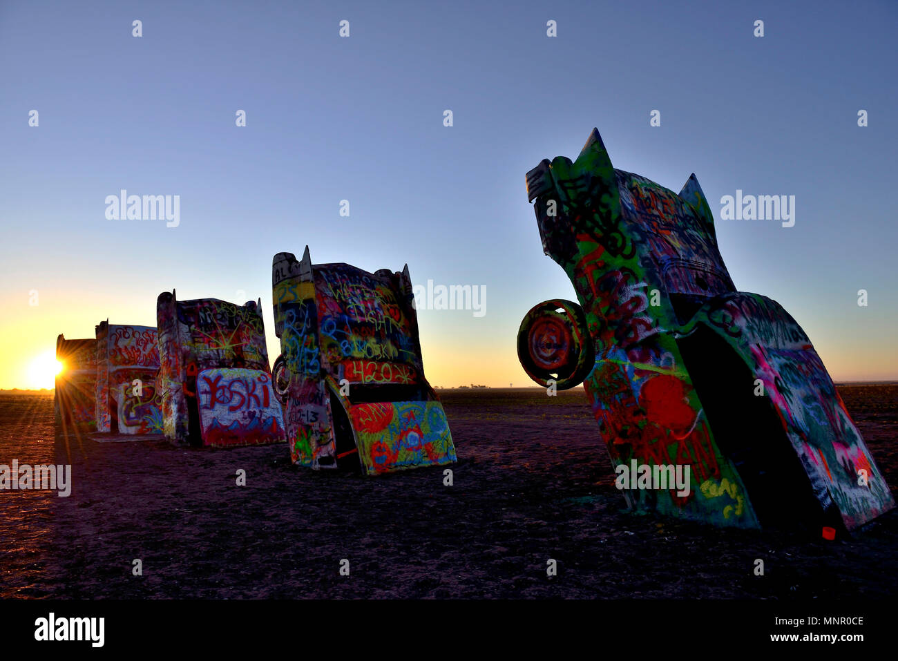 Sonnenuntergang hinter bemalten Cadillacs, Kunst im öffentlichen Raum installation Cadillac Ranch, Künstler Stanley Marsh 3, Route 66, Amarillo, Texas, USA Stockfoto