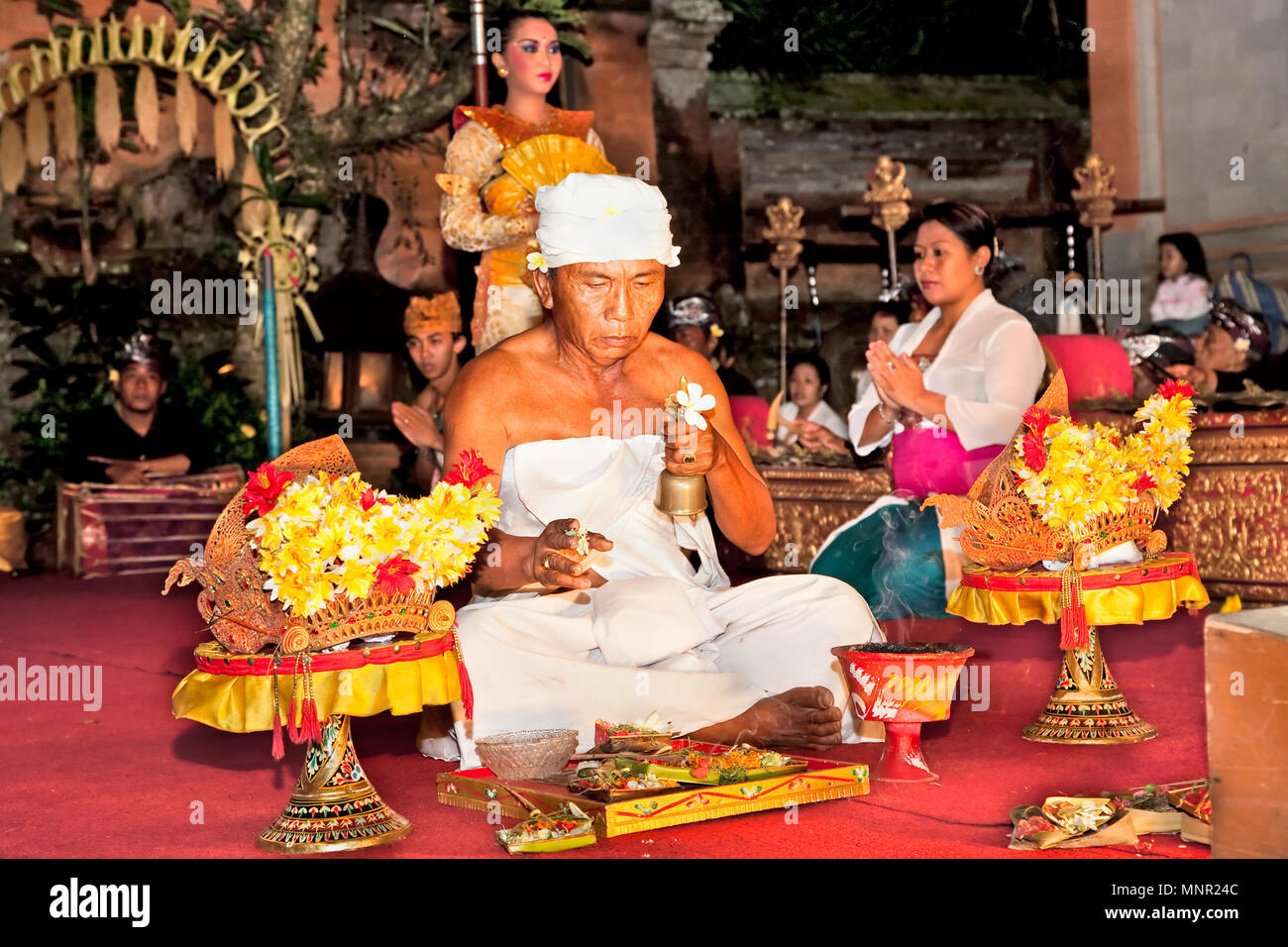 BALI - Januar 19: Legong Trance & Paradies Tanz in Ubud Palace. Vor der Leistung, Priester religiöse Zeremonie von Angeboten und segne alle akt Stockfoto