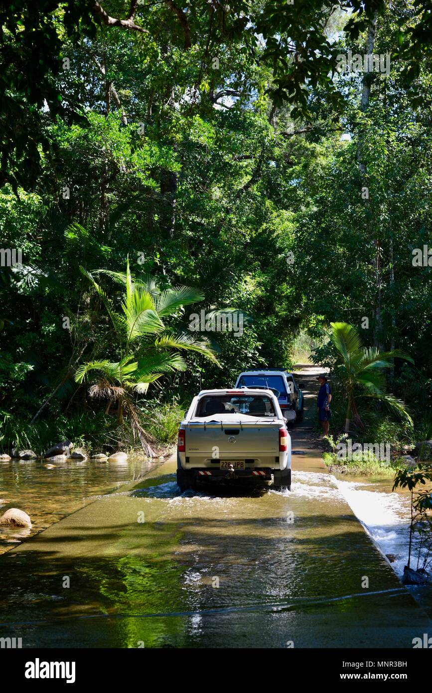 Fahrzeuge überqueren Sie einen Fluss überqueren auf dem Weg nach Jourama Falls, Bruce Hwy, Yuruga QLD, Australia Stockfoto