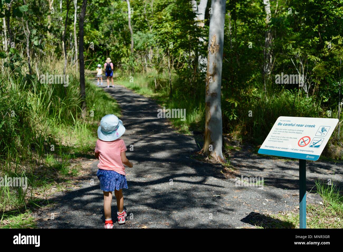Eine Mutter und Kinder zu Fuß auf einem Pfad in den Wald, Jourama Falls, Bruce Hwy, Yuruga QLD, Australia Stockfoto