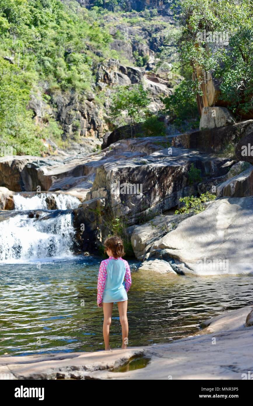 Ein junges Mädchen entspannt, während Sie einen Wasserfall, Jourama Falls, Bruce Hwy, Yuruga QLD, Australia Stockfoto