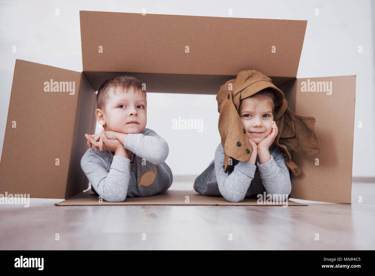 Zwei kleine Kinder, Junge und Mädchen spielen in Kartons. Konzept Foto. Kinder haben Spaß Stockfoto