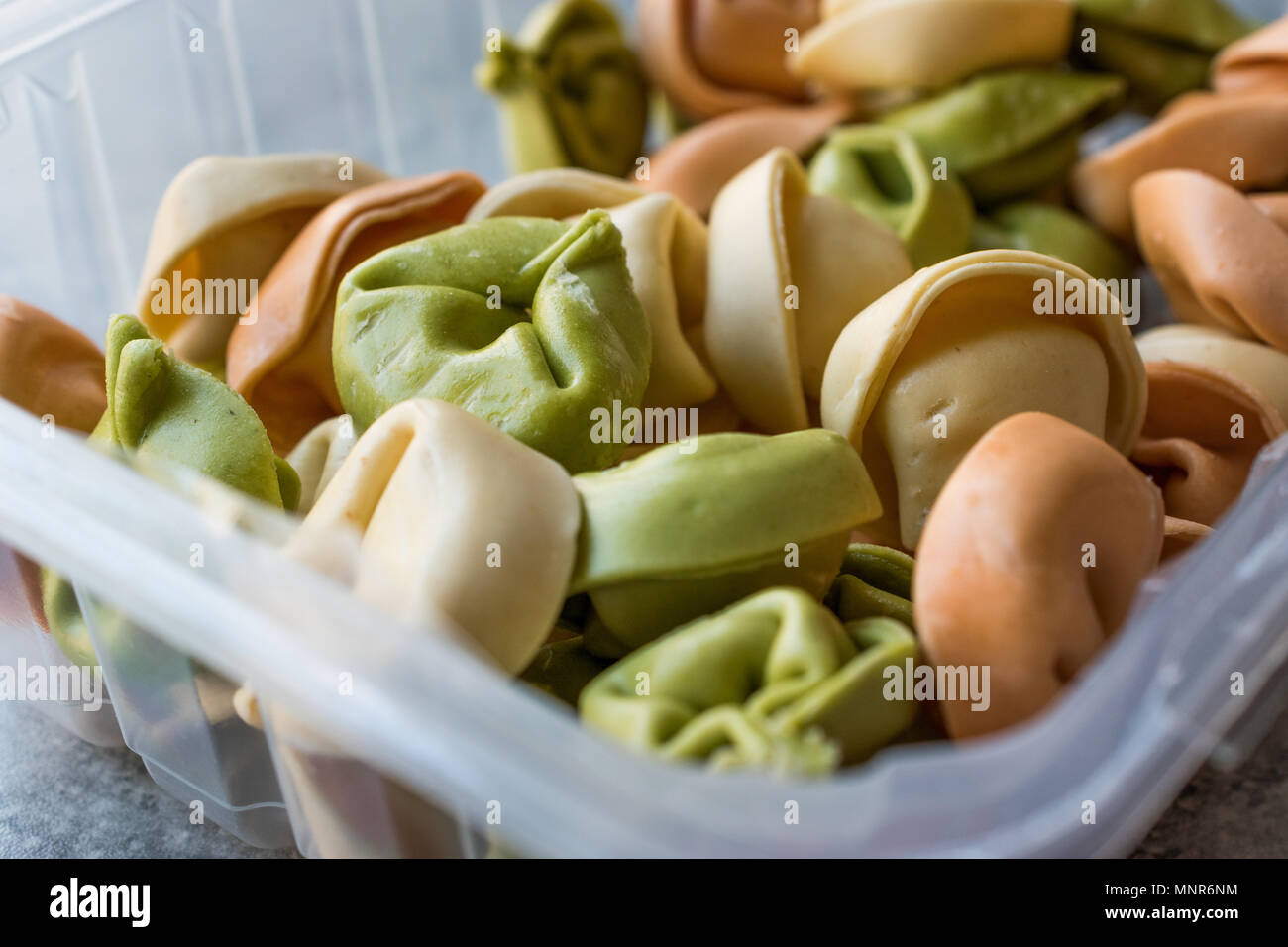 Farbige rohe Nudeln Tortellini in Kunststoffbox Multicolor/Bunt oder Tri gefärbt. Roh Essen. Stockfoto