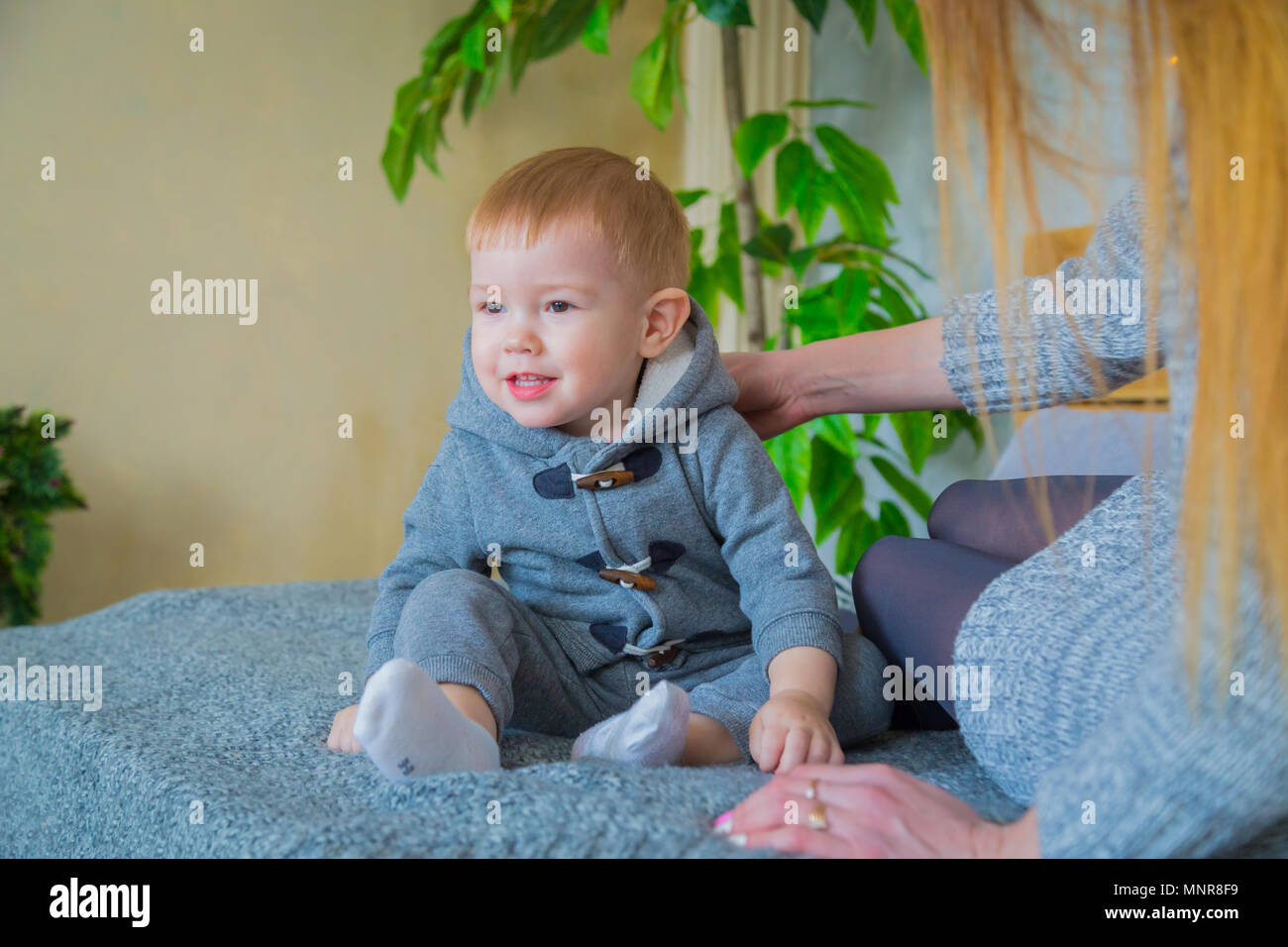 Glückliche junge Mutter und ihr Baby Sohn spielen Togerher Stockfoto