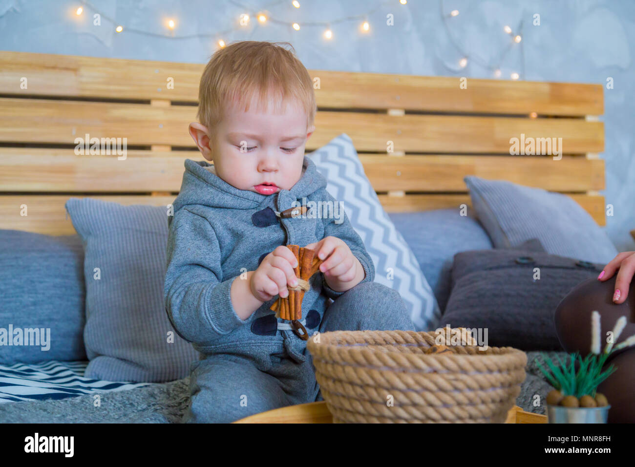 Baby Junge spielt mit Zimtstangen Stockfoto