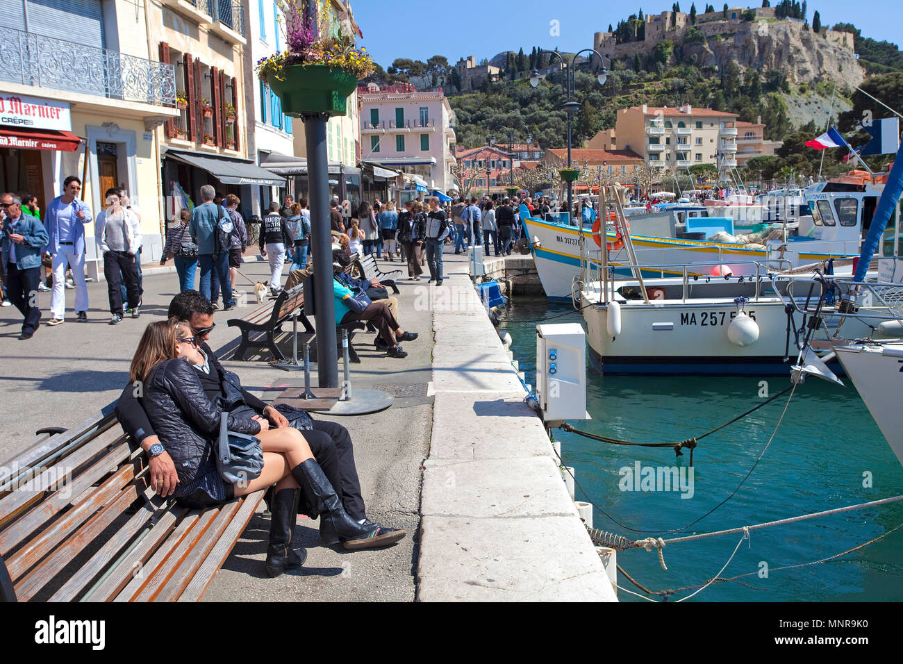 Die Menschen auf den Bänken am Hafen von Cassis, Bouches-du-Rhône der Region Provence-Alpes-Côte d'Azur, Südfrankreich, Frankreich, Europa Stockfoto