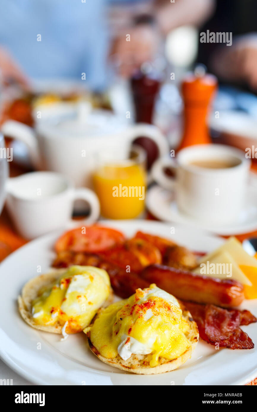 Köstliches Frühstück mit Eggs Benedict, Speck, Orangensaft und Kaffee Stockfoto