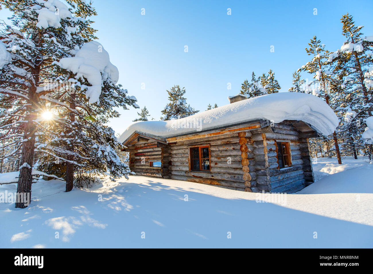 Schöne Winterlandschaft mit Holzhütte und schneebedeckten Bäumen Stockfoto