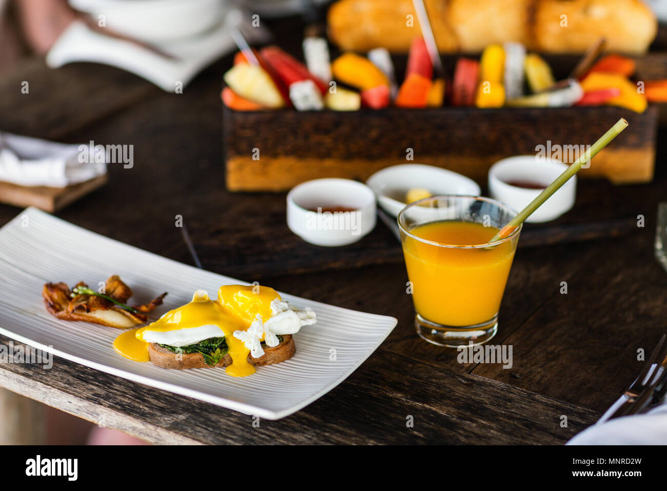 Pochierte Eier serviert zum Frühstück mit Speck und Saft Stockfoto