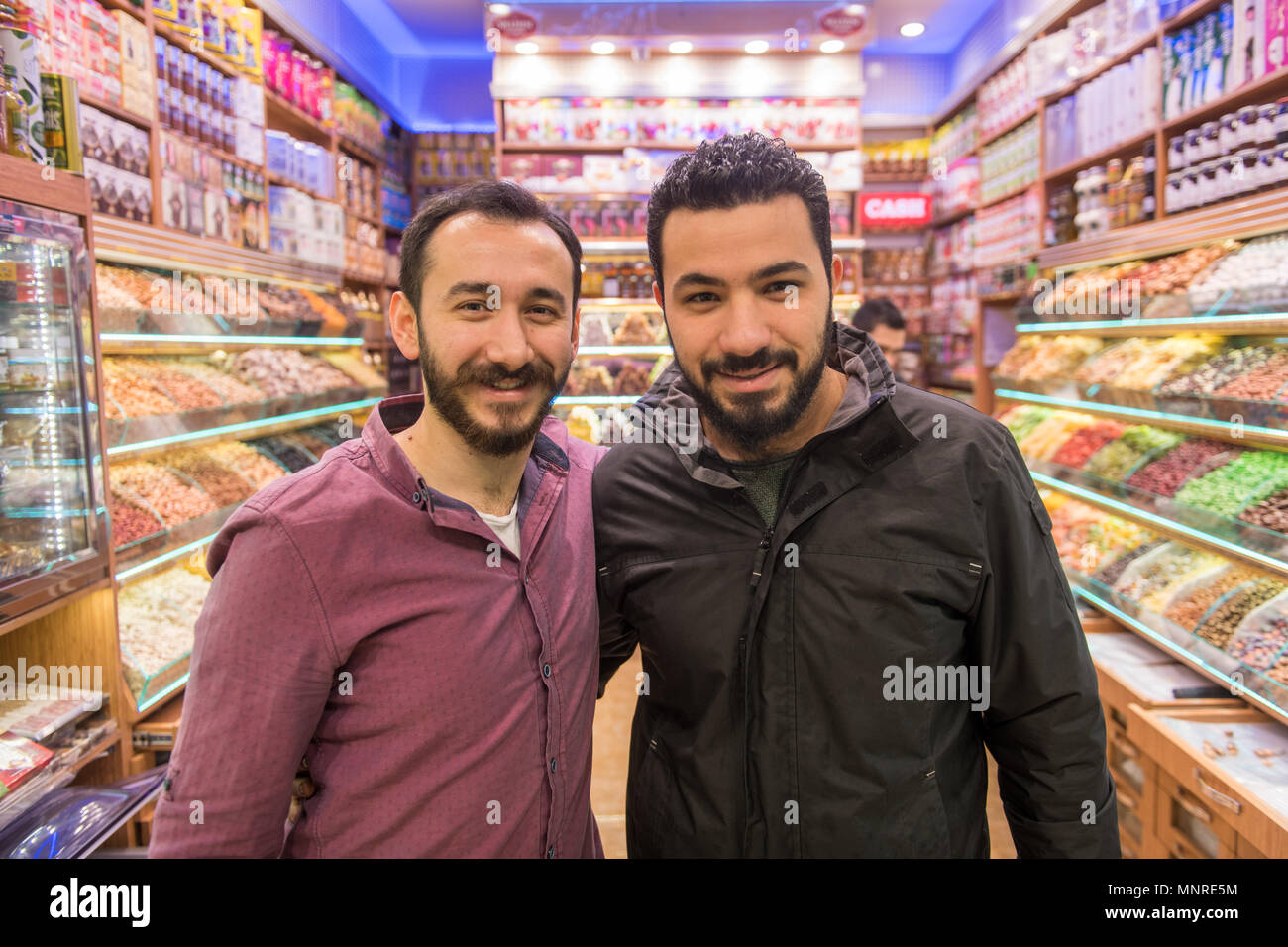 Zwei erwachsene Männchen Lächeln und posiert für Foto zusammen in einem Süßigkeiten und getrocknete Ware shop, Istanbul Spice Bazaar in der Türkei Stockfoto