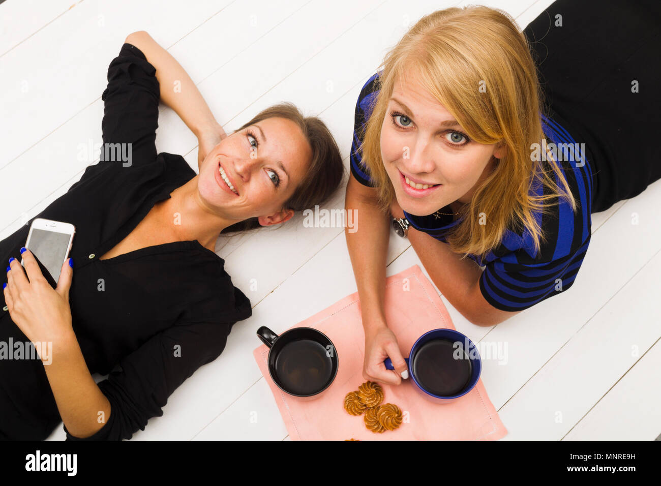 Zwei Mädchen auf weißem Holz- Hintergrund, Ansicht von oben, Studio, Beleuchtung Stockfoto