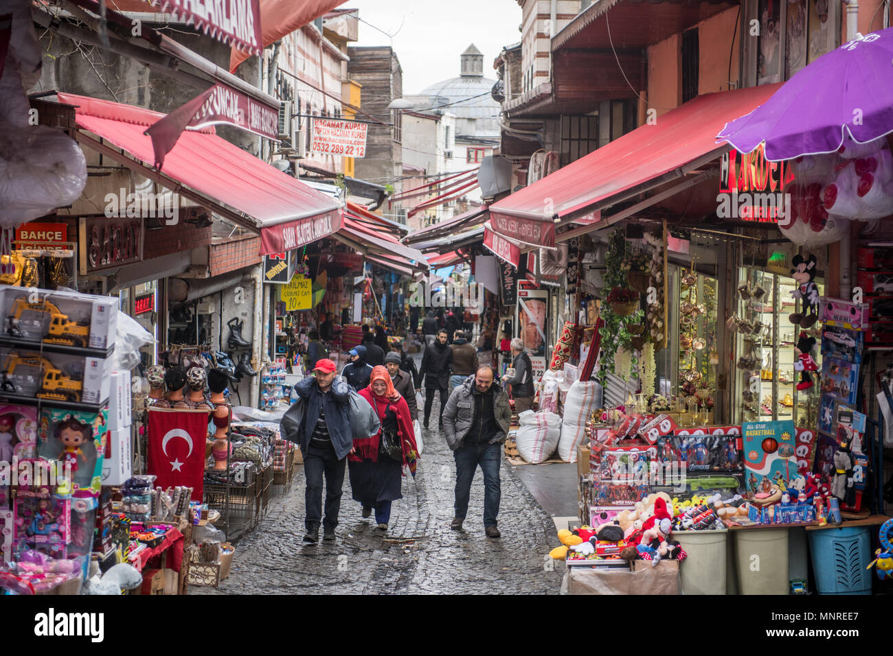 Menschen gehen, auf einem Hügel auf einer schmalen Straße, wo Geschäfte und Stände im Freien Markt Linie auf beiden Seiten des engen Raum, Istanbul, Türkei Stockfoto