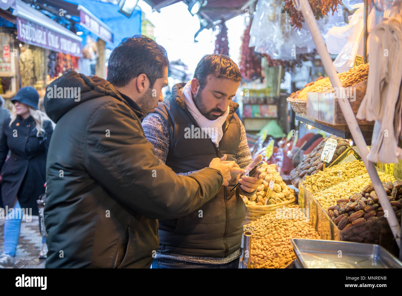 Zwei erwachsene Männchen und Blick auf Handy zusammen vor der Markt im Freien Markt, Istanbul, Türkei. Stockfoto