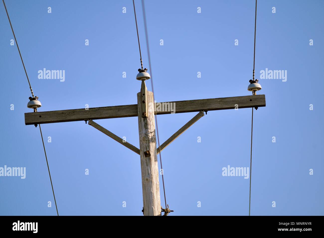 Kaneland, Illinois, USA. Eine schiefe, hölzernen Telefonmast entlang einer ländlichen Straße im Nordosten Illinois.. Die Vintage pole Auflistung auf einer Seite enthält Stockfoto