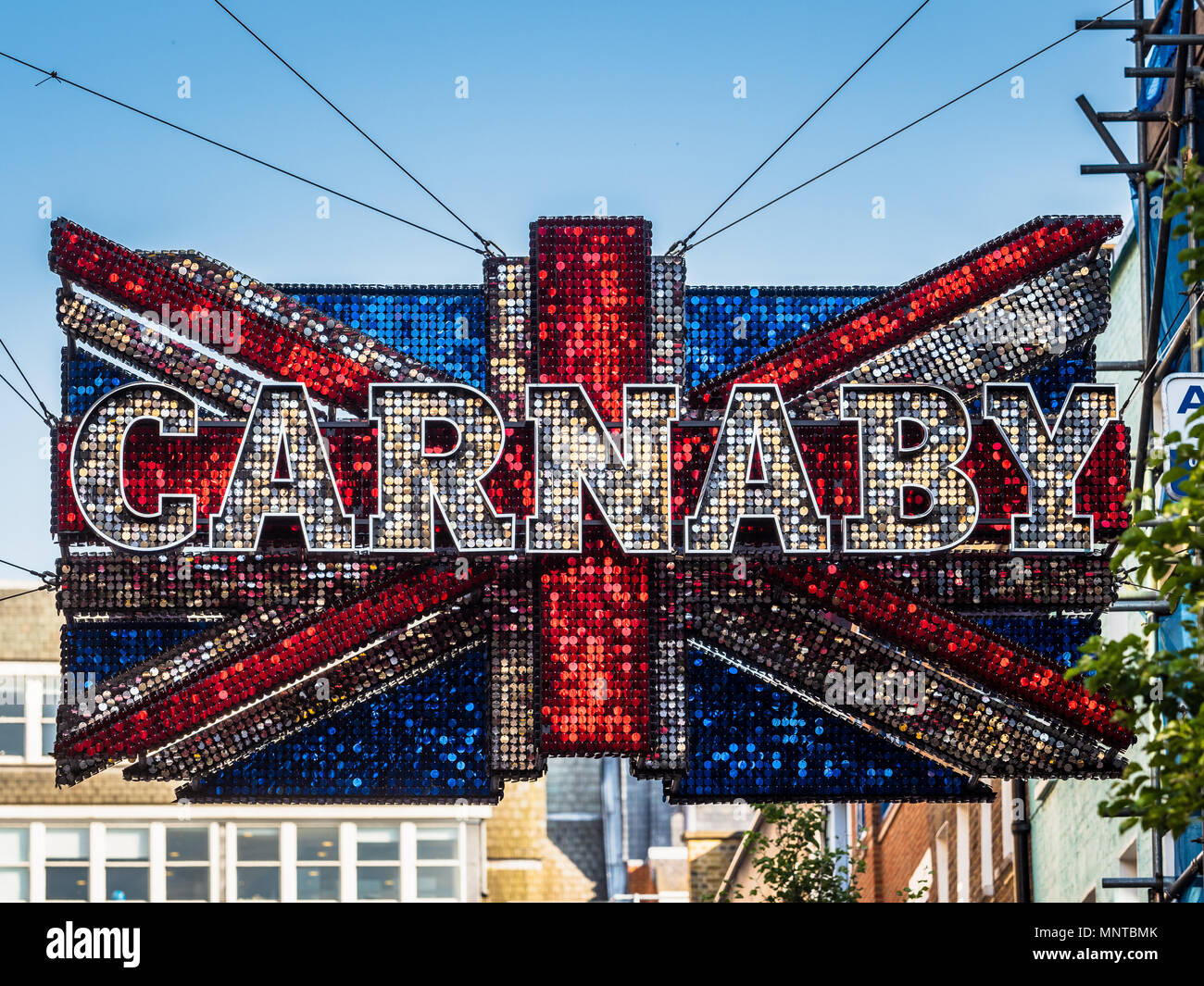 Riesige sequinned Union Jack Schild über der berühmten Londoner Carnaby Street fashion street in Londons West End hängt Stockfoto