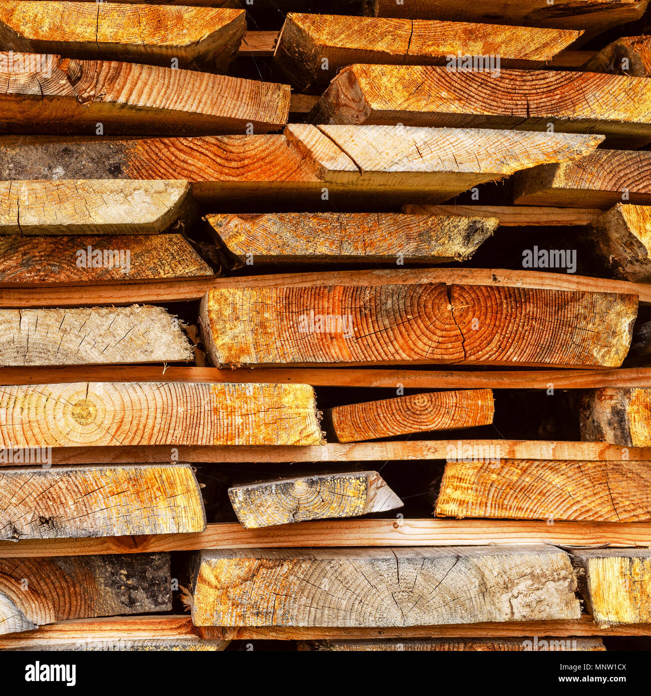 Stapel gestapelt Bauholz. Getrocknete Holz Bretter mit einem Knacken. Verschiedene Arten von Holz. Platz. Getönt. Close-up. Stockfoto