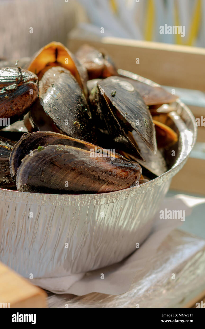 Frisch gekochte Miesmuscheln in eiserne Pfanne. Köstliche Meeresfrüchte. Muscheln essen. Selektive konzentrieren. Vertikale. Close-up. Stockfoto