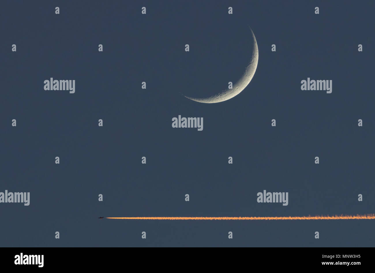 Jet fliegt unter dem Mond Stockfoto