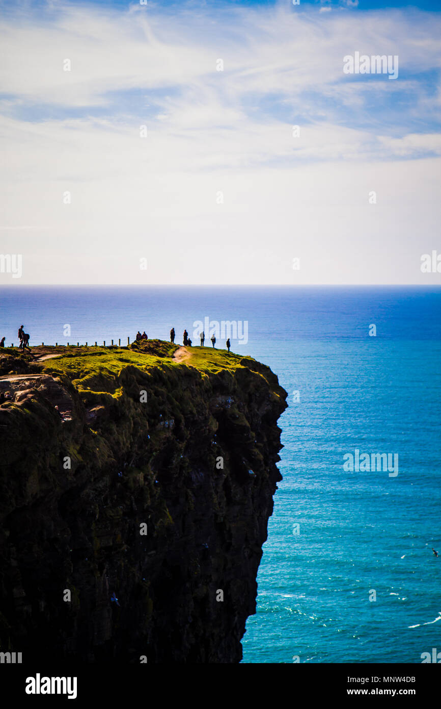 Touristen auf den Klippen von Moher an einem sonnigen Tag in der Grafschaft Clare, Irland Stockfoto