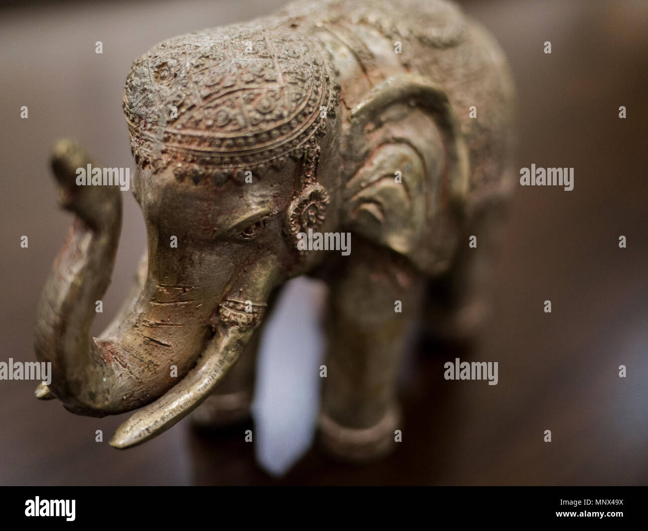 Nahaufnahme noch Leben der schönen geschnitzten Metall Elefant mit Holz- Hintergrund Stockfoto