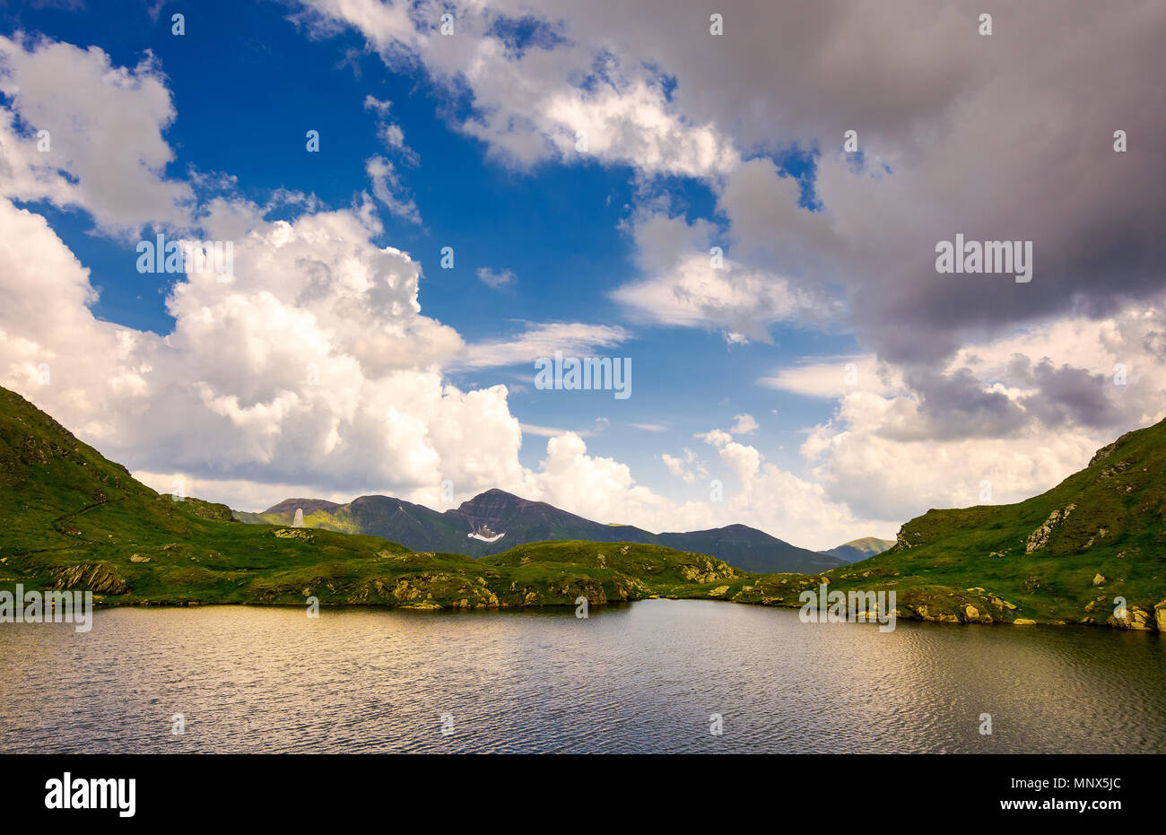 Traumhafte Wolkengebilde über die Capra See. erstaunlich Fagaras Berge in der Ferne. Stockfoto