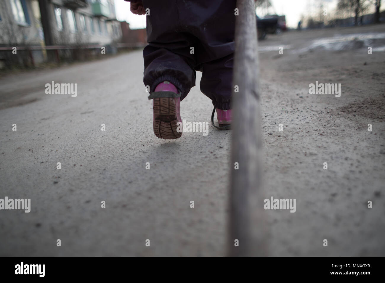 Foto von den Füßen eines walking Kind auf der Straße Ansicht von hinten Stockfoto