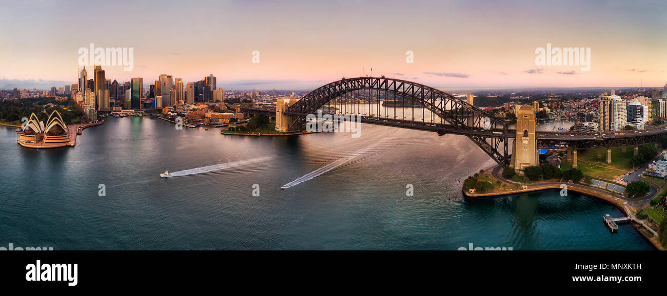 Sehenswürdigkeiten von Sydney City rund um den Hafen auf beiden Seiten der strandgebiete der Sydney Harbour Bridge in weiten Antenne panorama angeschlossen bei Sonnenaufgang. Stockfoto
