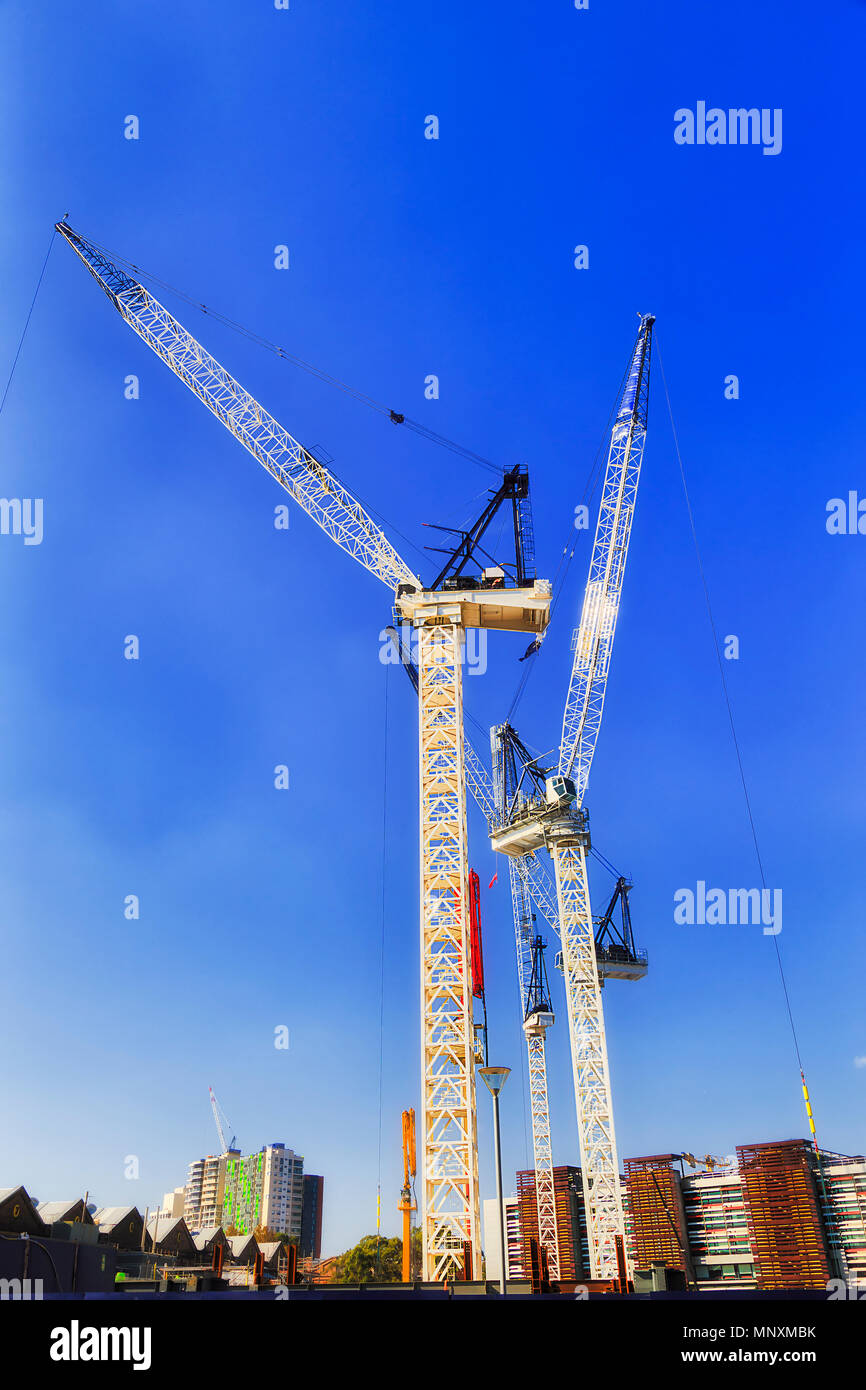 Baustelle des neuen Wohn- Geschäftshaus mit Hebezeuge Krane Materialien zu verwalten gegen blauen Himmel. Australische Bauboom in majo Stockfoto